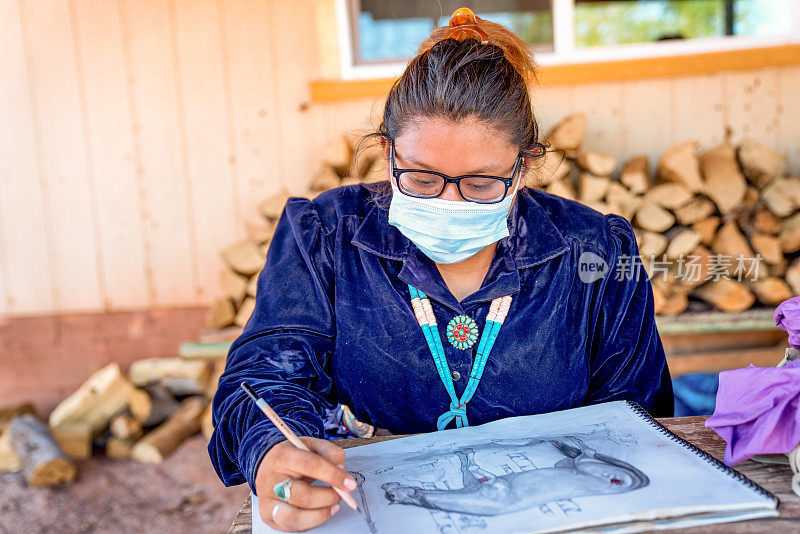 年轻的纳瓦霍女孩戴着covid -19面具在画画